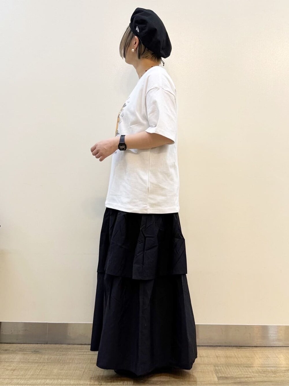 ホワイト系のTシャツ/カットソー、ブラック系のスカート、ホワイト系のショルダーバッグを着用したレディースの春コーディネートの4枚目の写真