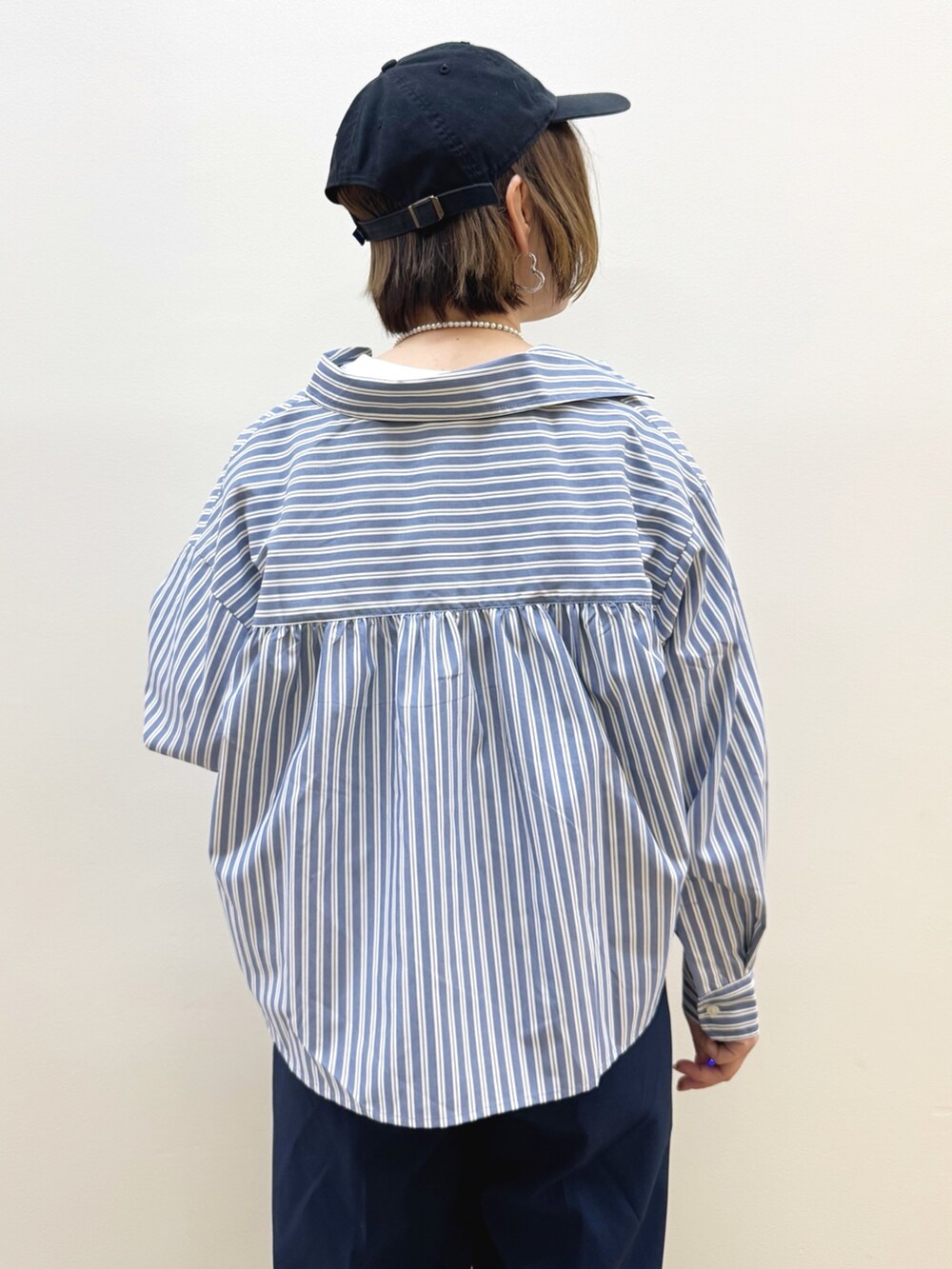 ホワイト系のショルダーバッグ、ブラウン系のドレスシューズ、ブルー系のその他パンツを着用したレディースの秋コーディネートの6枚目の写真