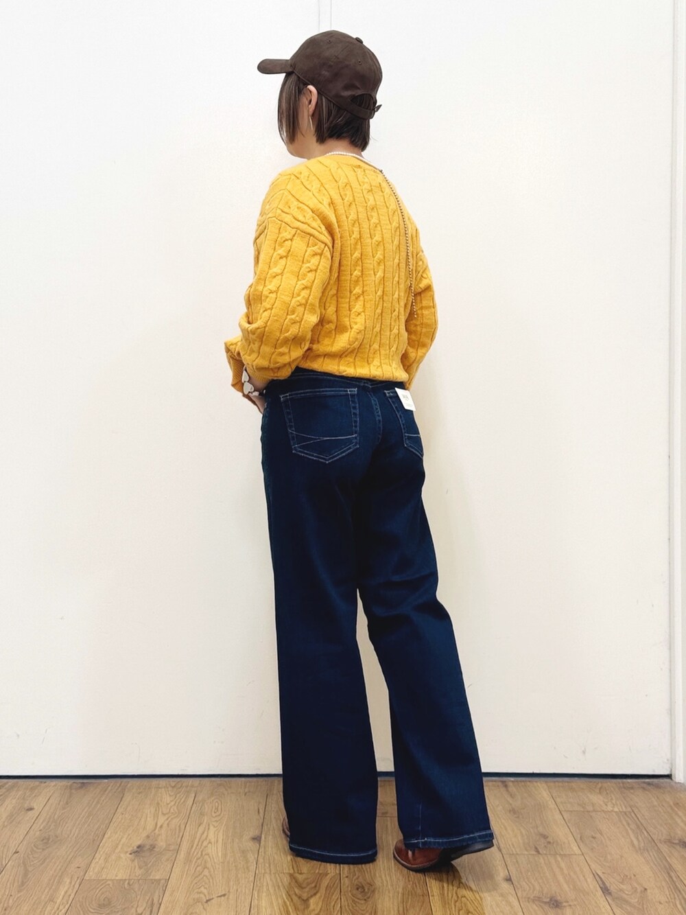 ブラウン系のドレスシューズ、ブルー系のデニムパンツ、イエロー系のニット/セーターを着用したレディースの秋コーディネートの8枚目の写真