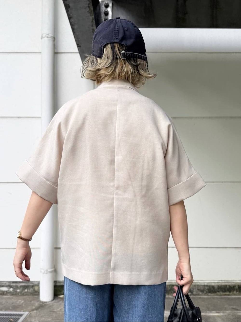 ベージュ系のテーラードジャケット、ブルー系のデニムパンツ、ホワイト系のTシャツ/カットソーを着用したレディースの春コーディネートの5枚目の写真