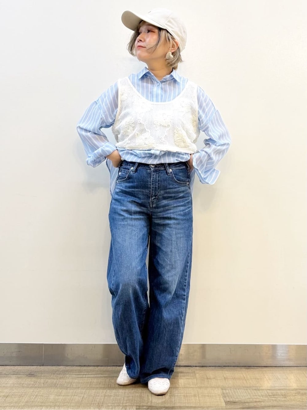 ブルー系のシャツ/ブラウス、ホワイト系のベスト、ブルー系のデニムパンツを着用したレディースの春コーディネートの7枚目の写真