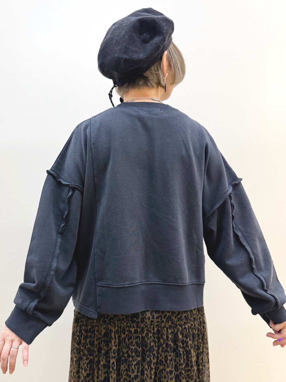 ブラック系のスウェット、ブラウン系のスカート、ホワイト系のショルダーバッグを着用したレディースの秋コーディネートの6枚目の写真