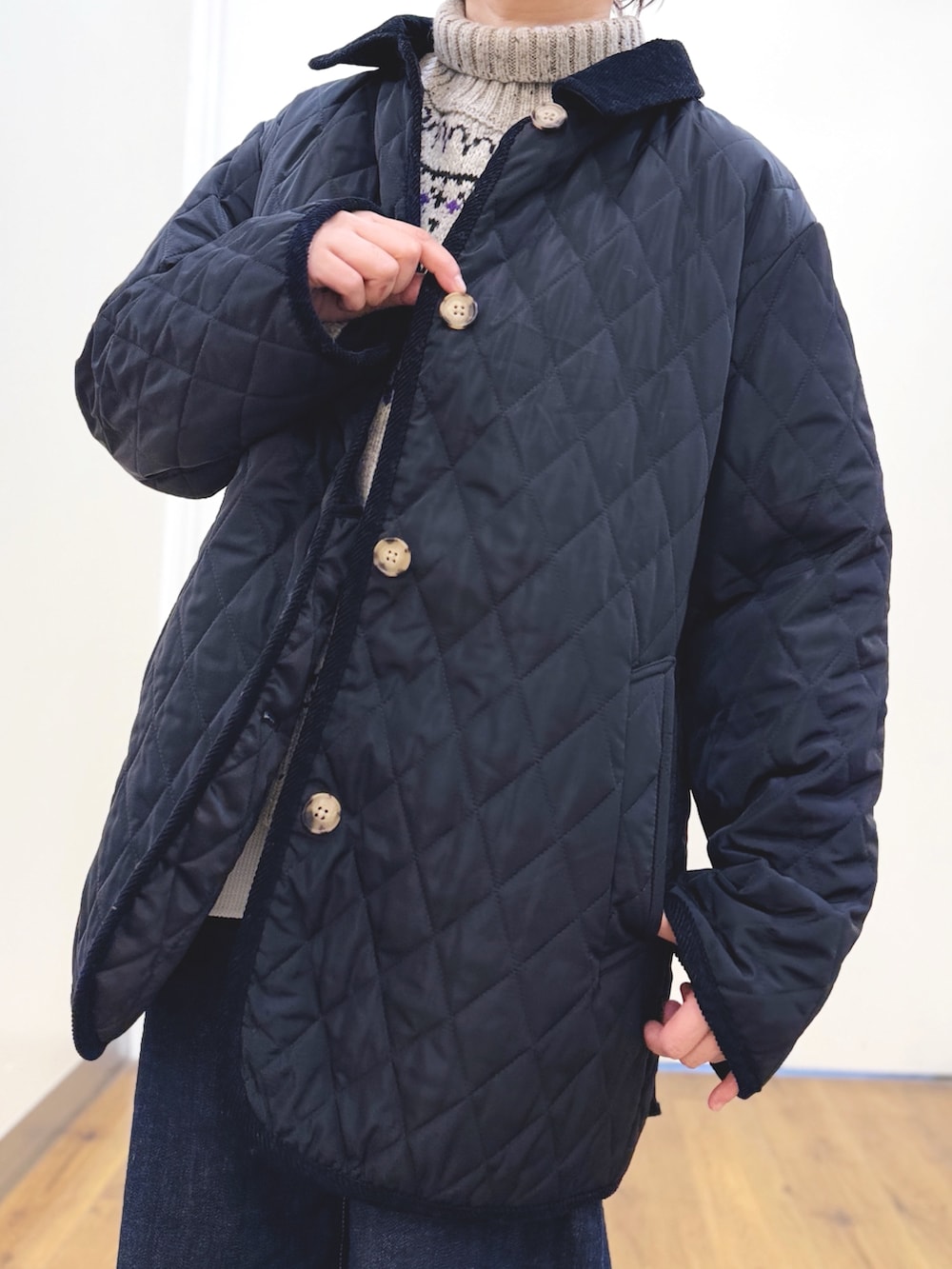 ホワイト系のニット/セーター、ブルー系のデニムパンツ、ブラック系のその他アウターを着用したレディースの冬コーディネートの5枚目の写真