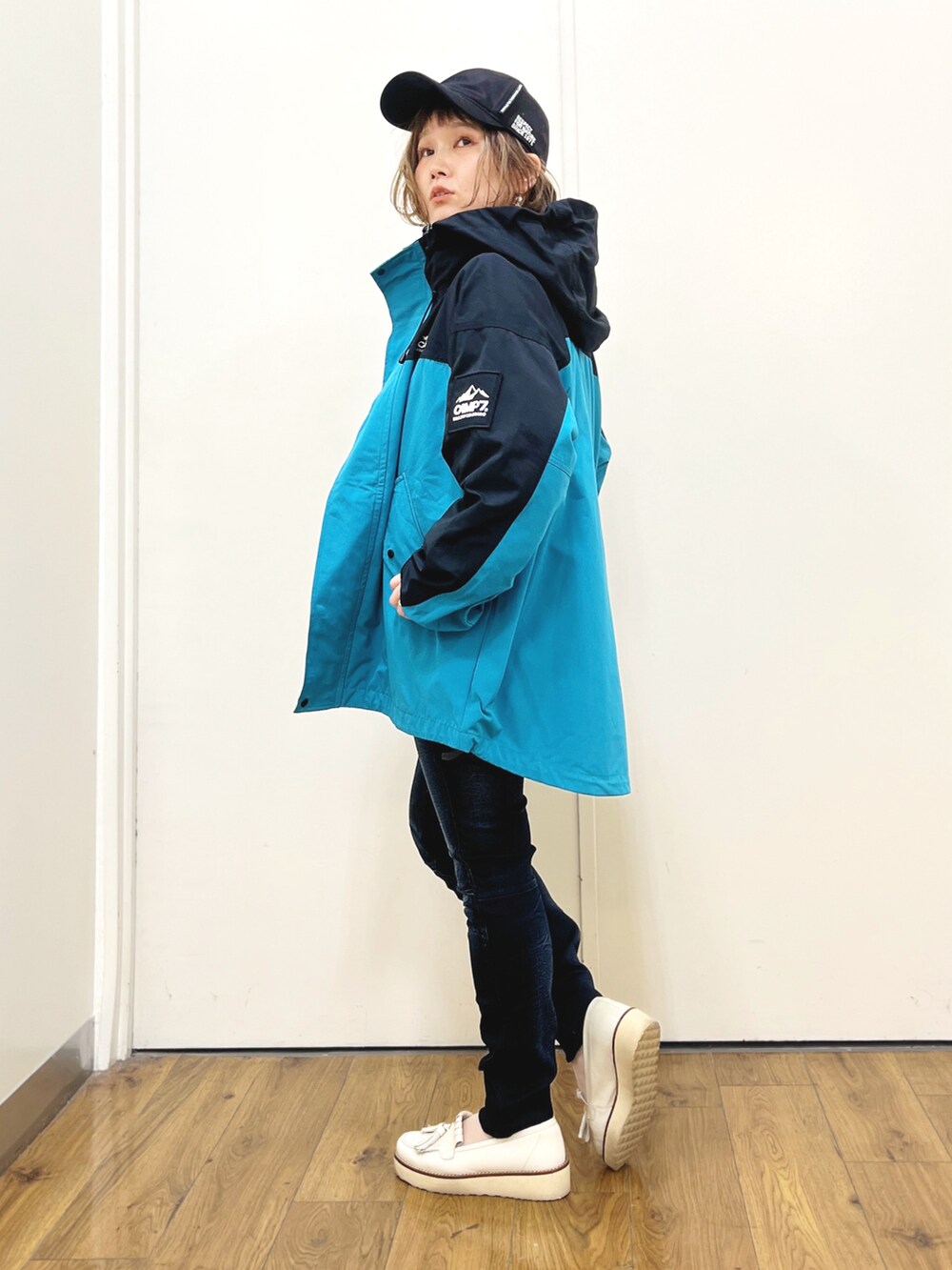 グレー系のスウェット、ブルー系のデニムパンツ、ブルー系のマウンテンパーカーを着用したレディースの冬コーディネートの4枚目の写真