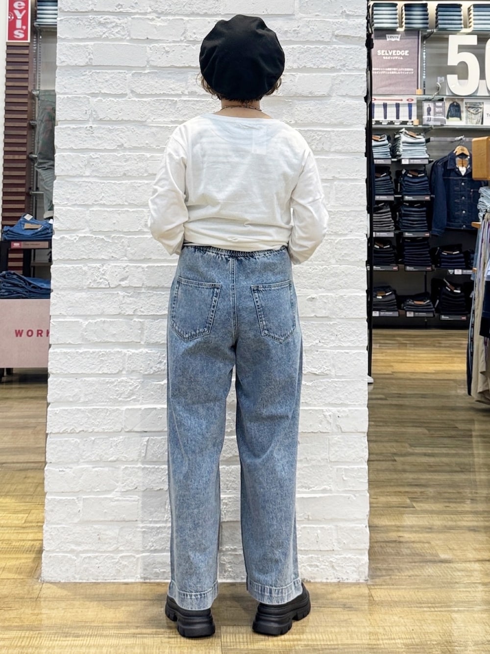 ブラック系のショルダーバッグ、ブラック系のその他シューズ、ブルー系のデニムパンツを着用したレディースの秋コーディネートの8枚目の写真