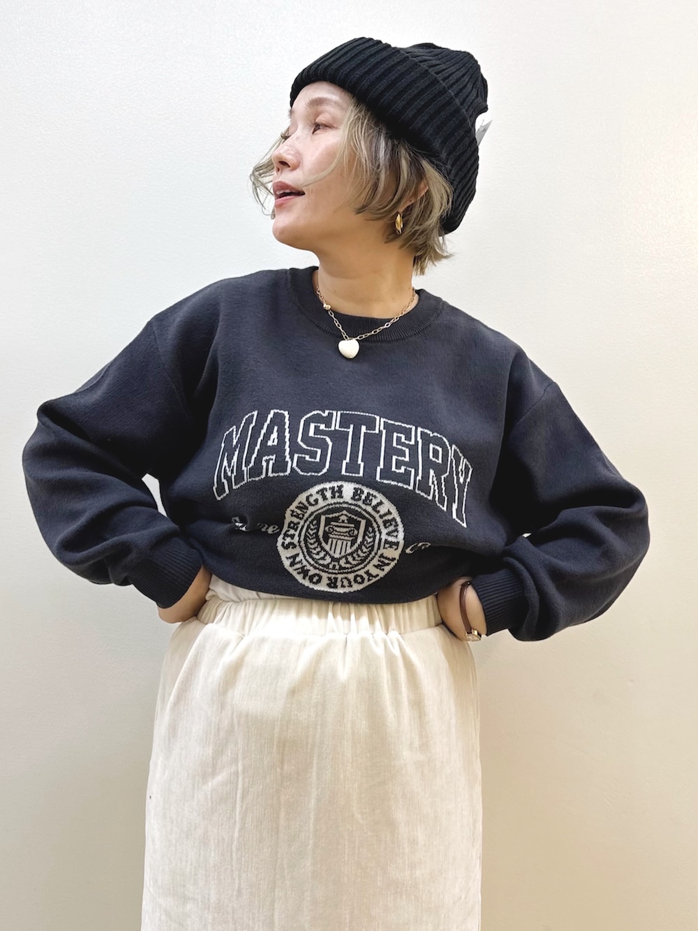 ブラック系のショルダーバッグ、ホワイト系のスカート、ブラック系のニット/セーターを着用したレディースの秋コーディネートの10枚目の写真