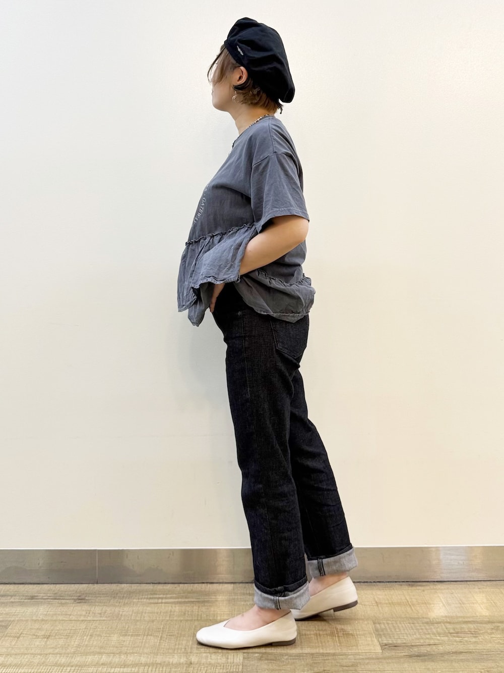グレー系のTシャツ/カットソー、ホワイト系のスカート、ブラック系のデニムパンツを着用したレディースの春コーディネートの8枚目の写真
