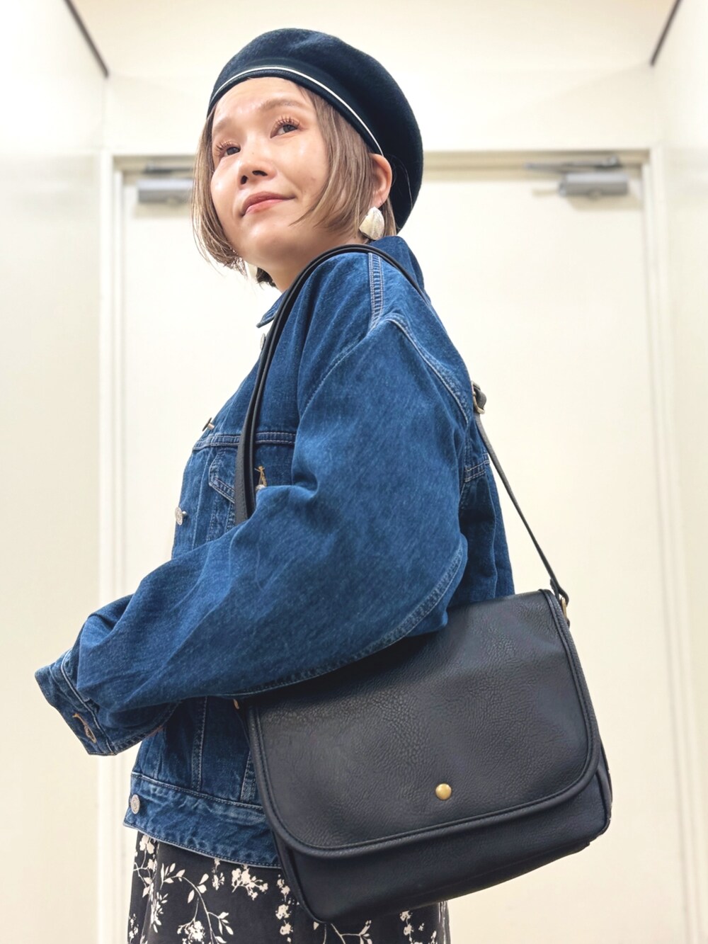 ブルー系のデニムジャケット、ブラック系のスカート、ブラック系のショルダーバッグを着用したレディースの秋コーディネートの10枚目の写真