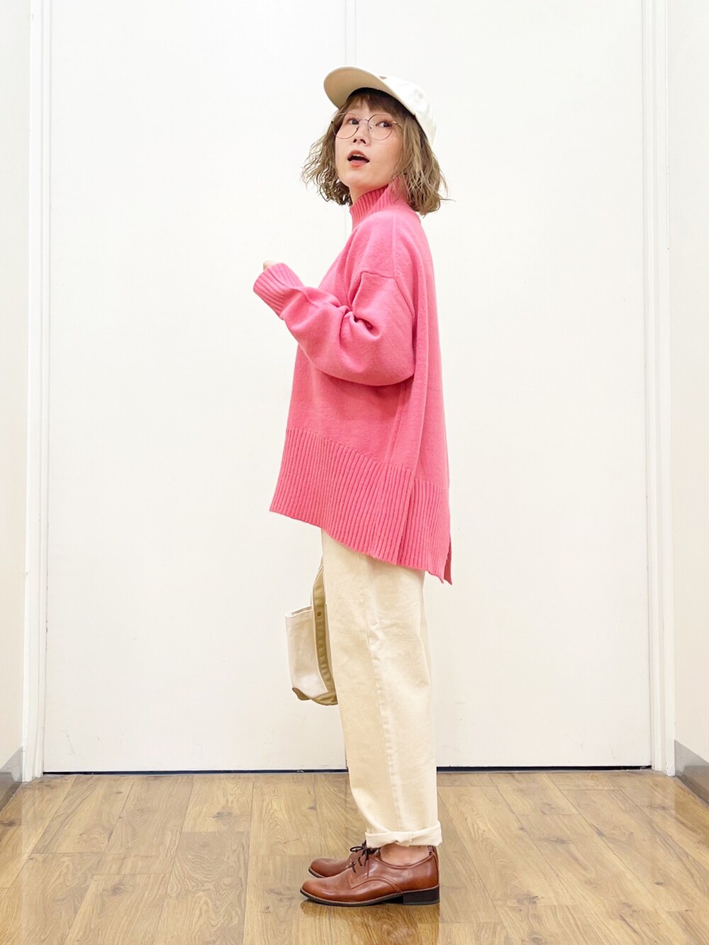 ピンク系のニット/セーター、ホワイト系のデニムパンツ、ブラウン系のドレスシューズを着用したレディースの秋コーディネートの3枚目の写真