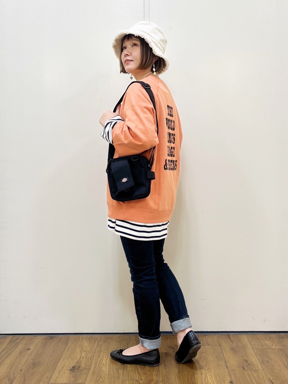 オレンジ系のTシャツ/カットソー、ブルー系のTシャツ/カットソー、ブルー系のデニムパンツを着用したレディースの冬コーディネートの2枚目の写真