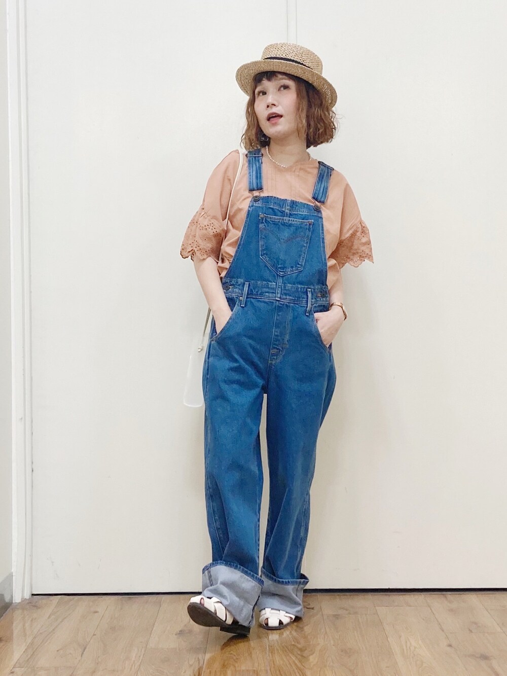 オレンジ系のシャツ/ブラウス、ブルー系のサロペット/オーバーオール、ホワイト系のサンダルを着用したレディースの夏コーディネートの2枚目の写真