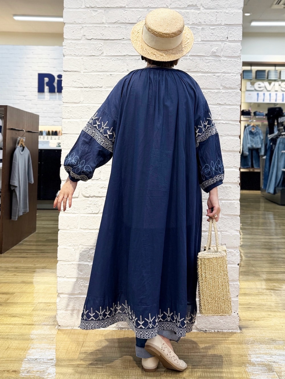 ブルー系のデニムパンツ、ブルー系のシャツワンピース、ホワイト系のTシャツ/カットソーを着用したレディースの春コーディネートの4枚目の写真