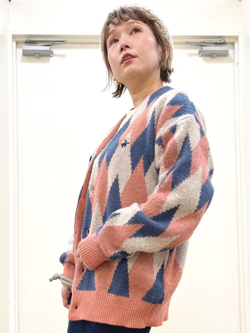 ピンク系のカーディガン/ボレロ、ブルー系のデニムスカート、ホワイト系のTシャツ/カットソーを着用したレディースの秋コーディネートの3枚目の写真