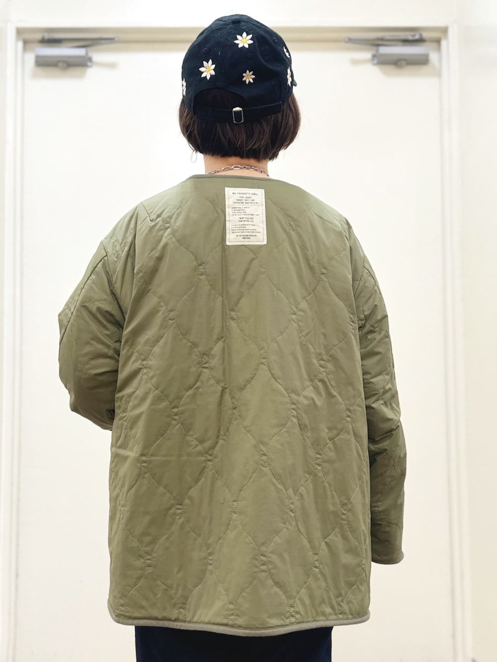 ブラック系のブーツ、ブルー系のデニムパンツ、グリーン系のブルゾンを着用したレディースの秋コーディネートの4枚目の写真