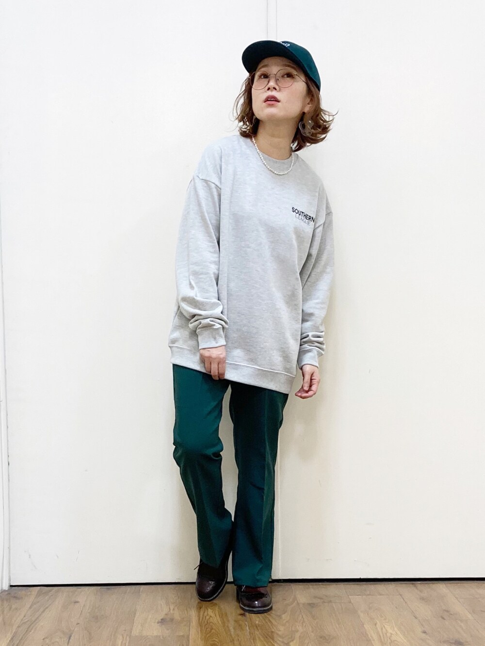 ブラック系のその他パンツ、ブラック系のローファー、グリーン系のスウェットを着用したレディースの冬コーディネートの4枚目の写真