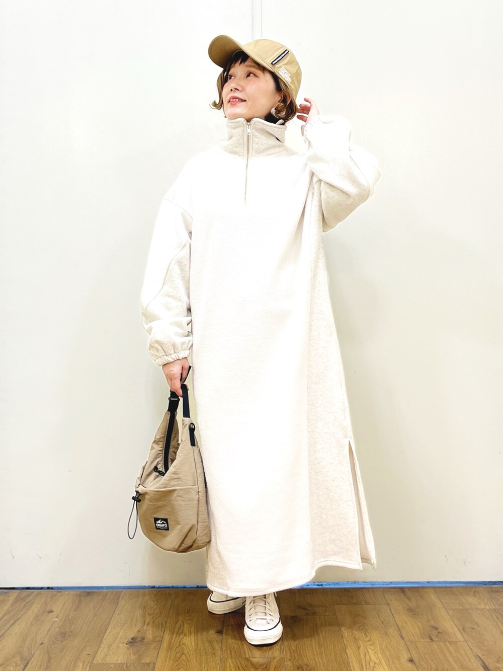 ホワイト系のワンピース、ベージュ系のショルダーバッグ、ホワイト系のニット/セーターを着用したレディースの冬コーディネートの2枚目の写真