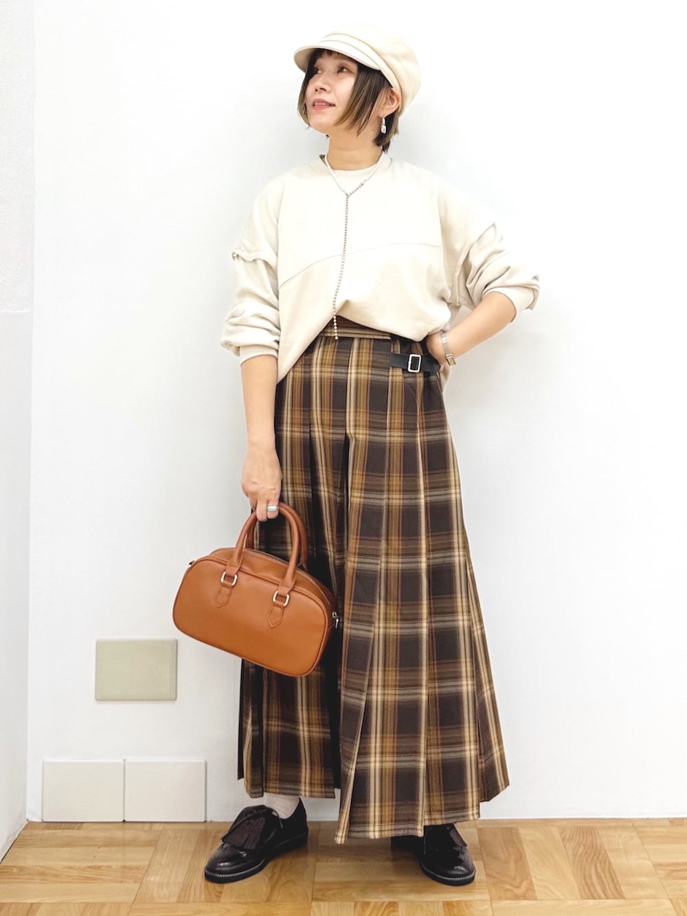 ベージュ系のスウェット、イエロー系のスカート、イエロー系のショルダーバッグを着用したレディースの秋コーディネートの7枚目の写真