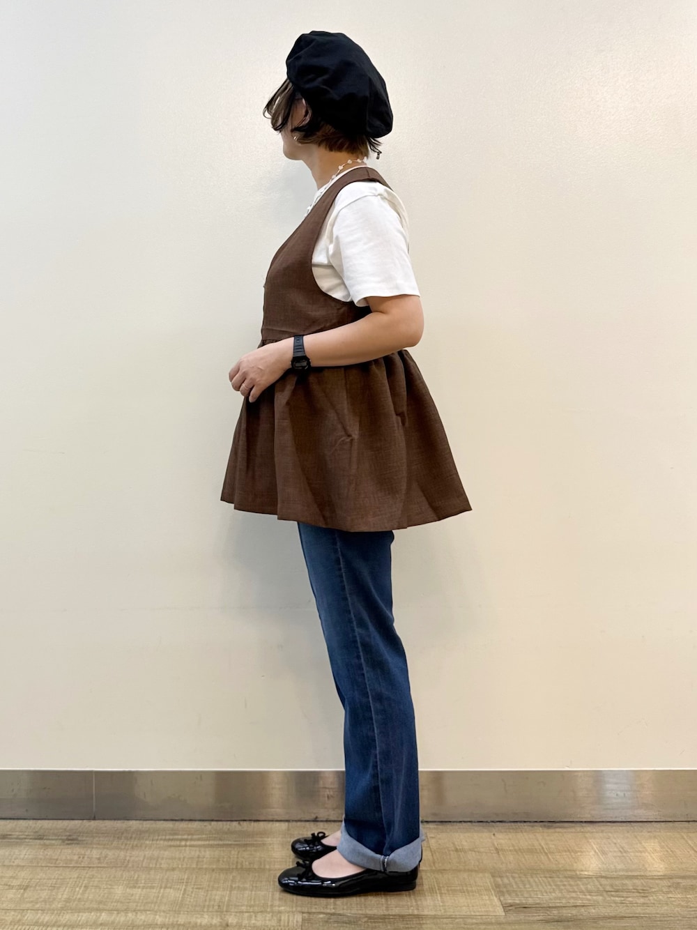 ブルー系のデニムパンツ、ホワイト系のTシャツ/カットソー、ブラウン系のベストを着用したレディースの夏コーディネートの3枚目の写真