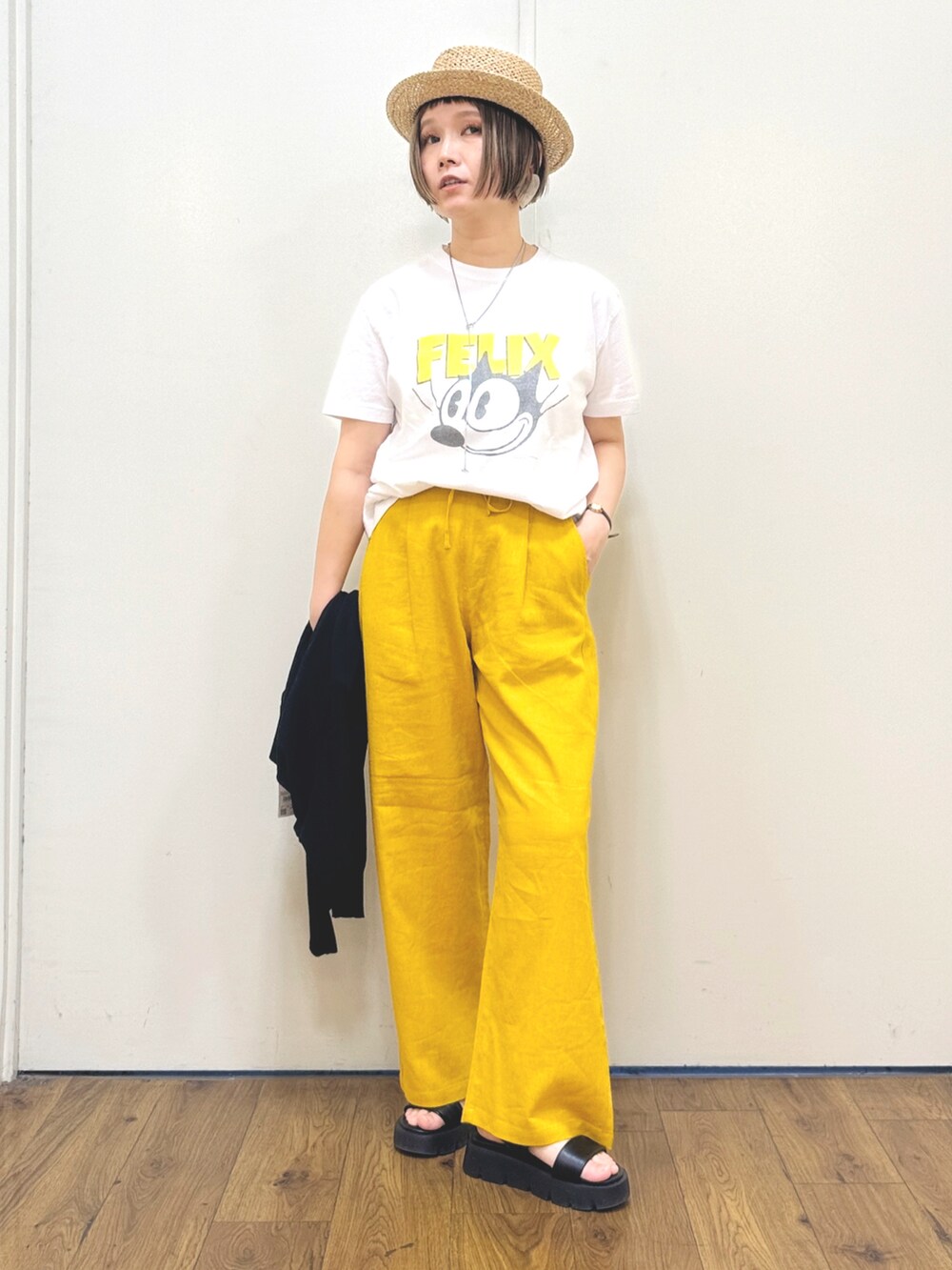 ブラック系のカーディガン/ボレロ、ホワイト系のTシャツ/カットソー、ブラック系のサンダルを着用したレディースの春コーディネートの2枚目の写真