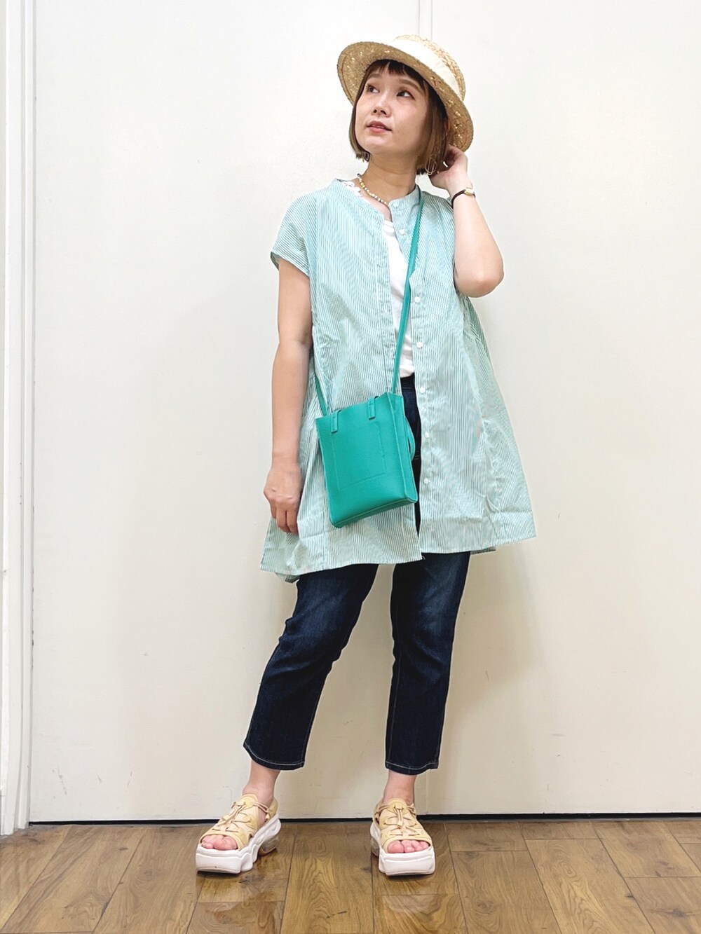 グリーン系のシャツ/ブラウス、ブルー系のデニムパンツ、ベージュ系のサンダルを着用したレディースの夏コーディネートの3枚目の写真