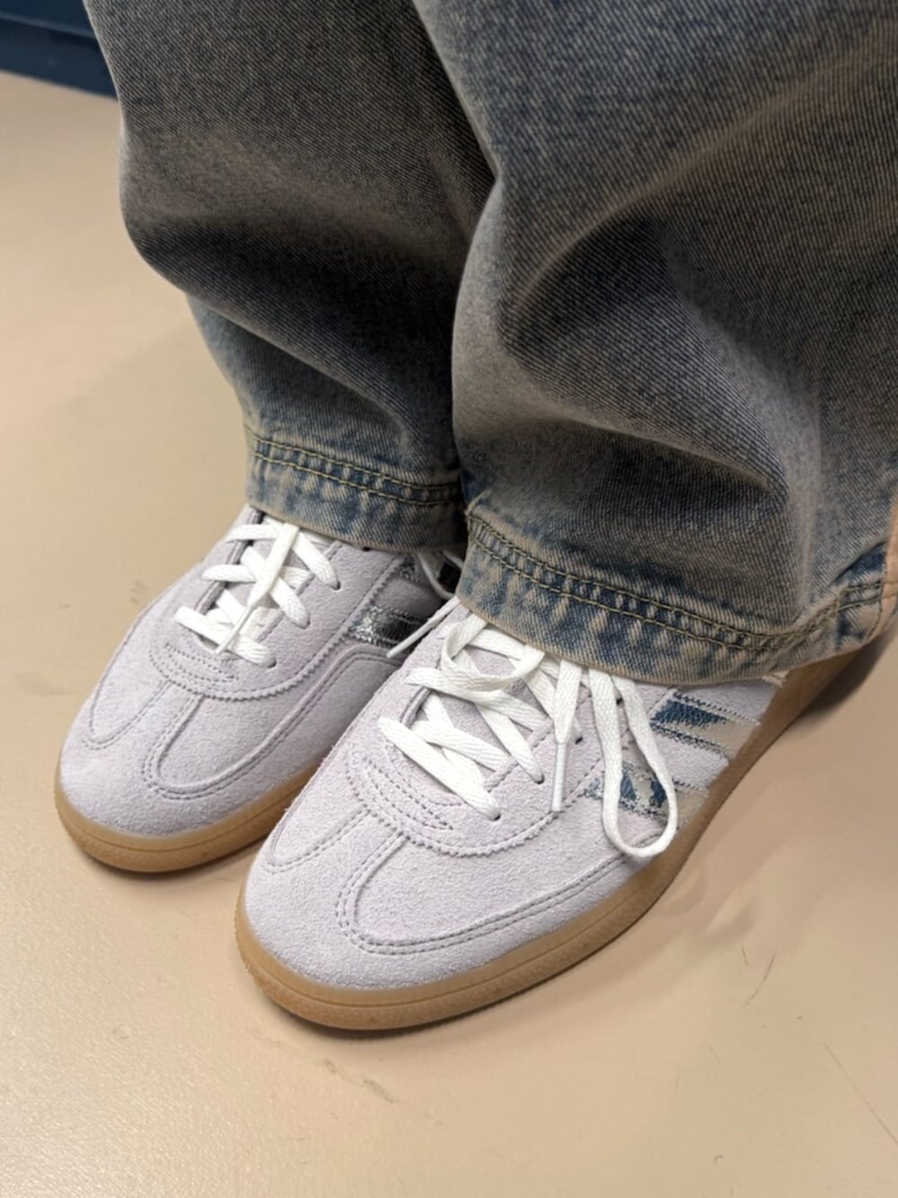 ブルー系のデニムパンツ、ブルー系のデニムジャケット、グレー系のスニーカーを着用したレディースの秋コーディネートの2枚目の写真