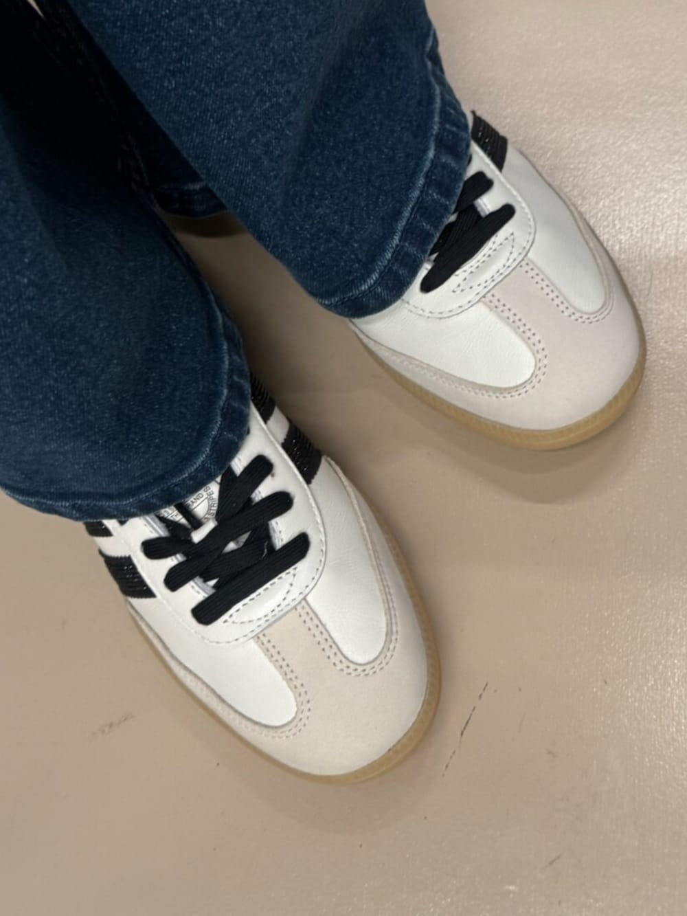 ブルー系のデニムパンツ、ホワイト系のスウェット、ホワイト系のスニーカーを着用したレディースの冬コーディネートの2枚目の写真