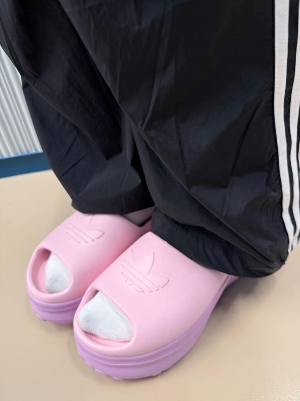 ホワイト系のサンダル、ブラック系のパンツ、ブラック系のジャージを着用したレディースの夏コーディネートの2枚目の写真