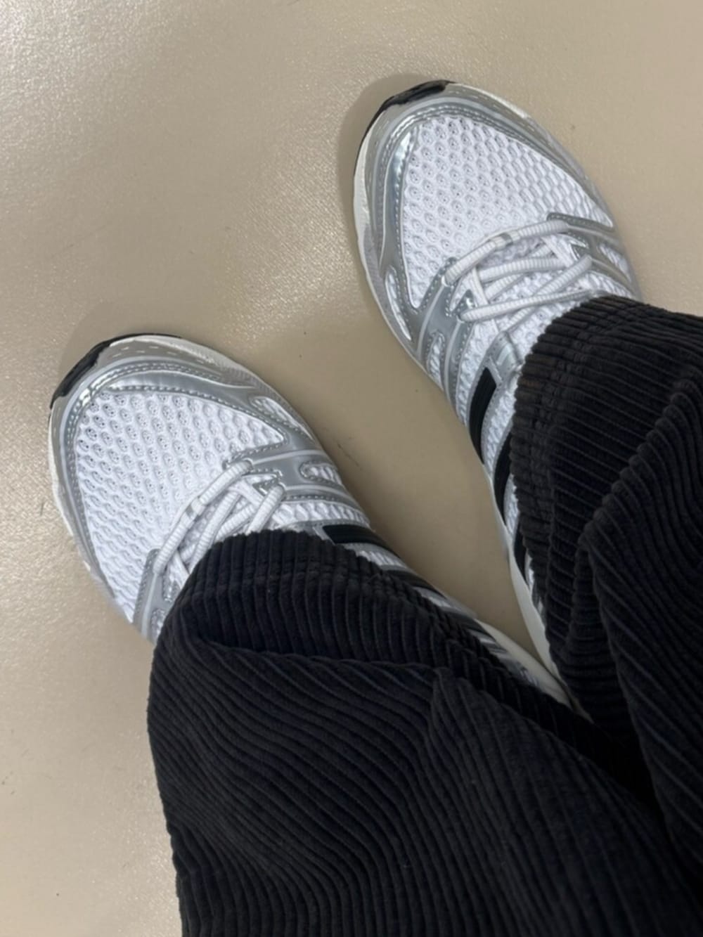 シルバー系のスニーカー、ブラック系のスウェットパンツ、ホワイト系のTシャツ/カットソーを着用したレディースの冬コーディネートの2枚目の写真