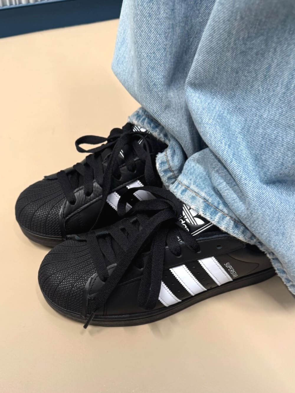 ブラック系のスニーカー、ブラック系のTシャツ/カットソー、ブラック系のショルダーバッグを着用したレディースの夏コーディネートの2枚目の写真