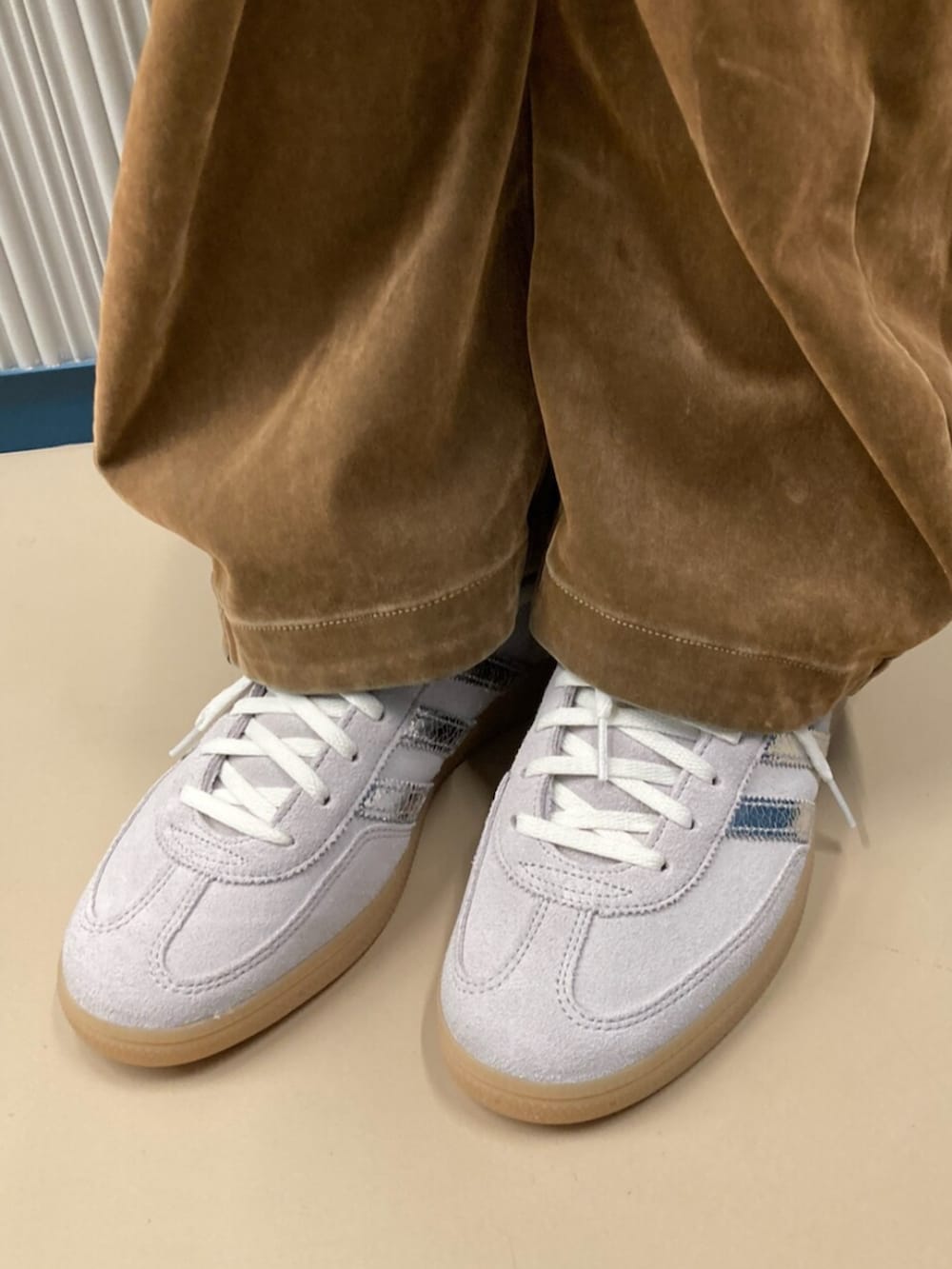 グレー系のスニーカー、ブラウン系のブルゾン、ブラウン系のその他パンツを着用したレディースの秋コーディネートの2枚目の写真