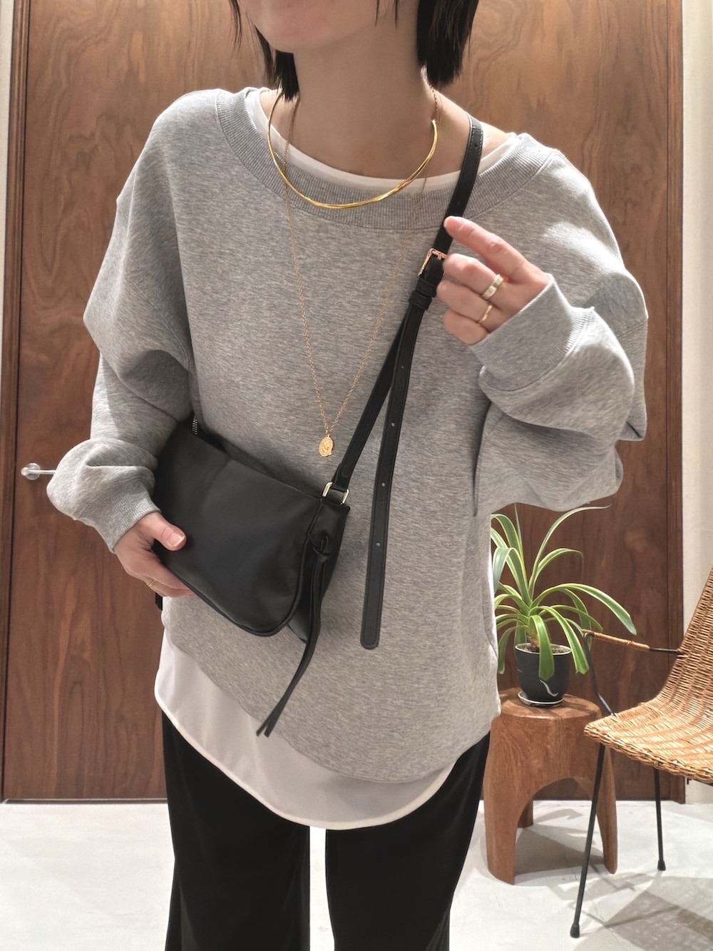 グレー系のTシャツ/カットソー、ブラック系のショルダーバッグ、ホワイト系のシャツ/ブラウスを着用したレディースの冬コーディネートの6枚目の写真