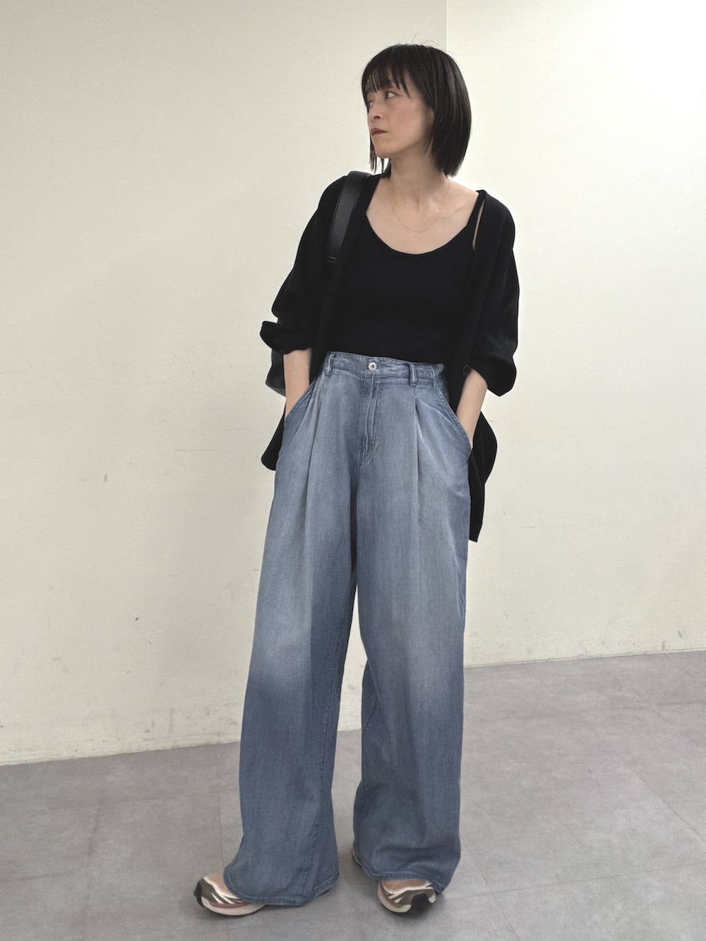 ブラック系のノーカラージャケット、ブラック系のニット/セーター、ブルー系のその他パンツを着用したレディースの春コーディネートの8枚目の写真