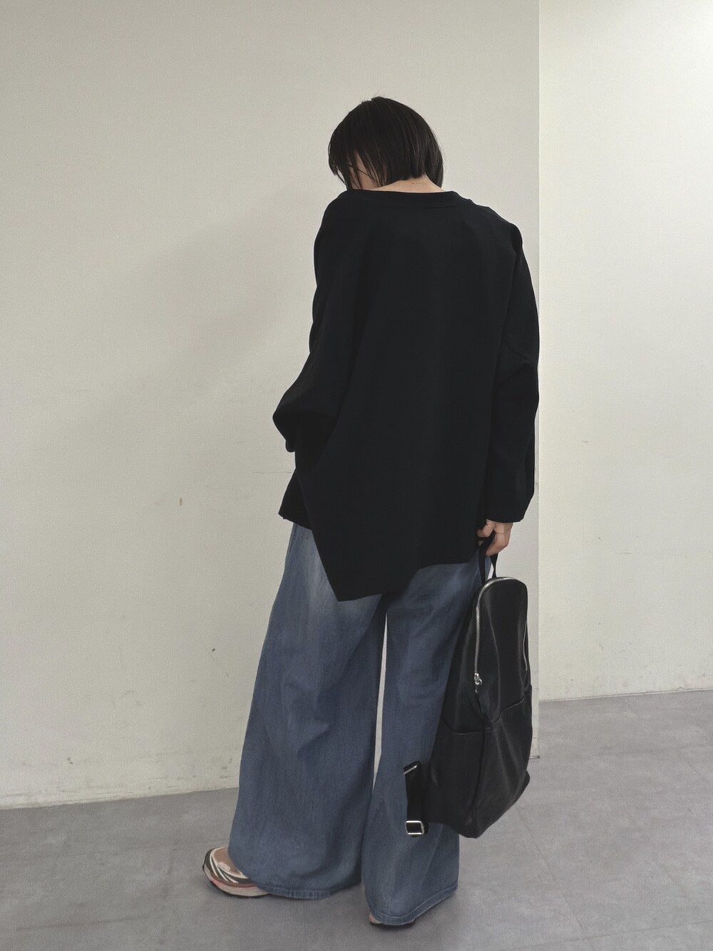 ブラック系のノーカラージャケット、ブラック系のニット/セーター、ブルー系のその他パンツを着用したレディースの春コーディネートの5枚目の写真