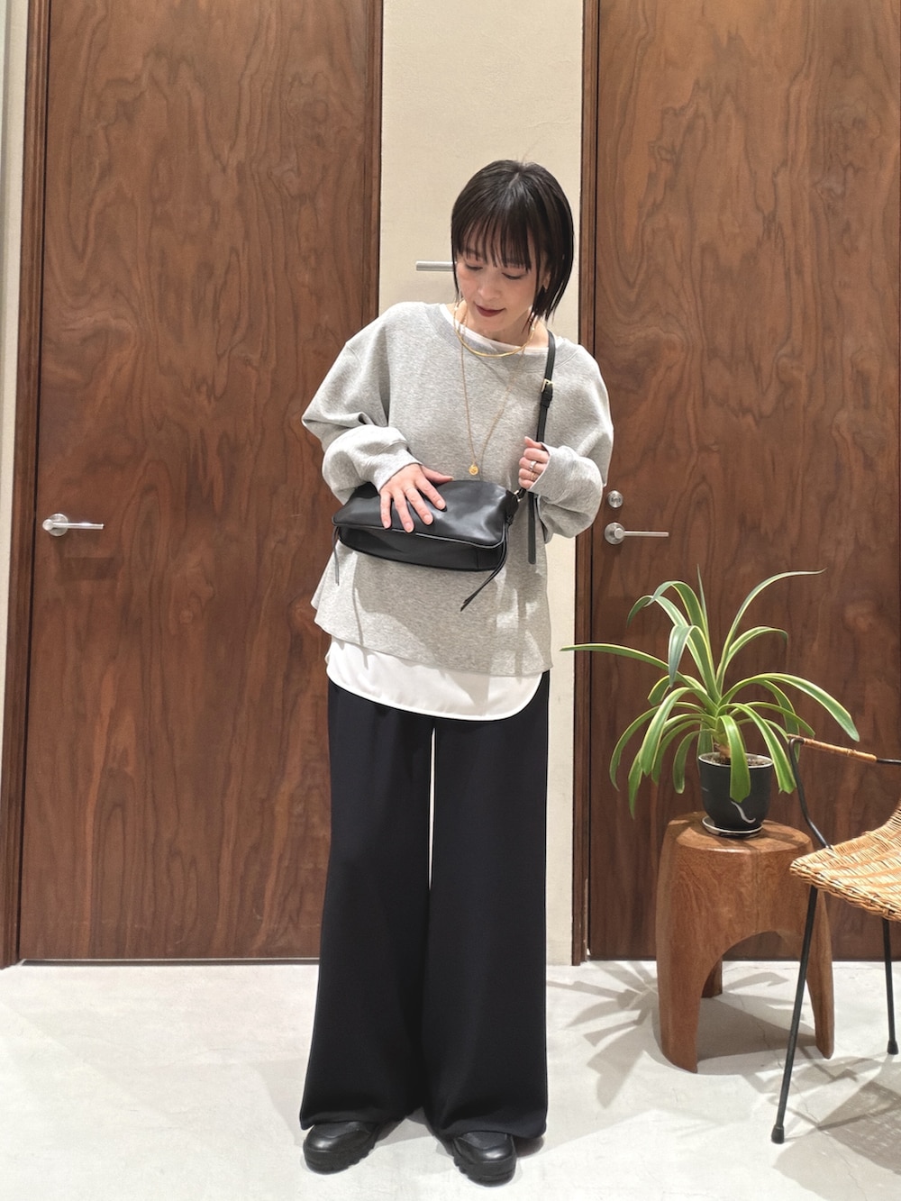 グレー系のTシャツ/カットソー、ブラック系のショルダーバッグ、ホワイト系のシャツ/ブラウスを着用したレディースの冬コーディネートの3枚目の写真