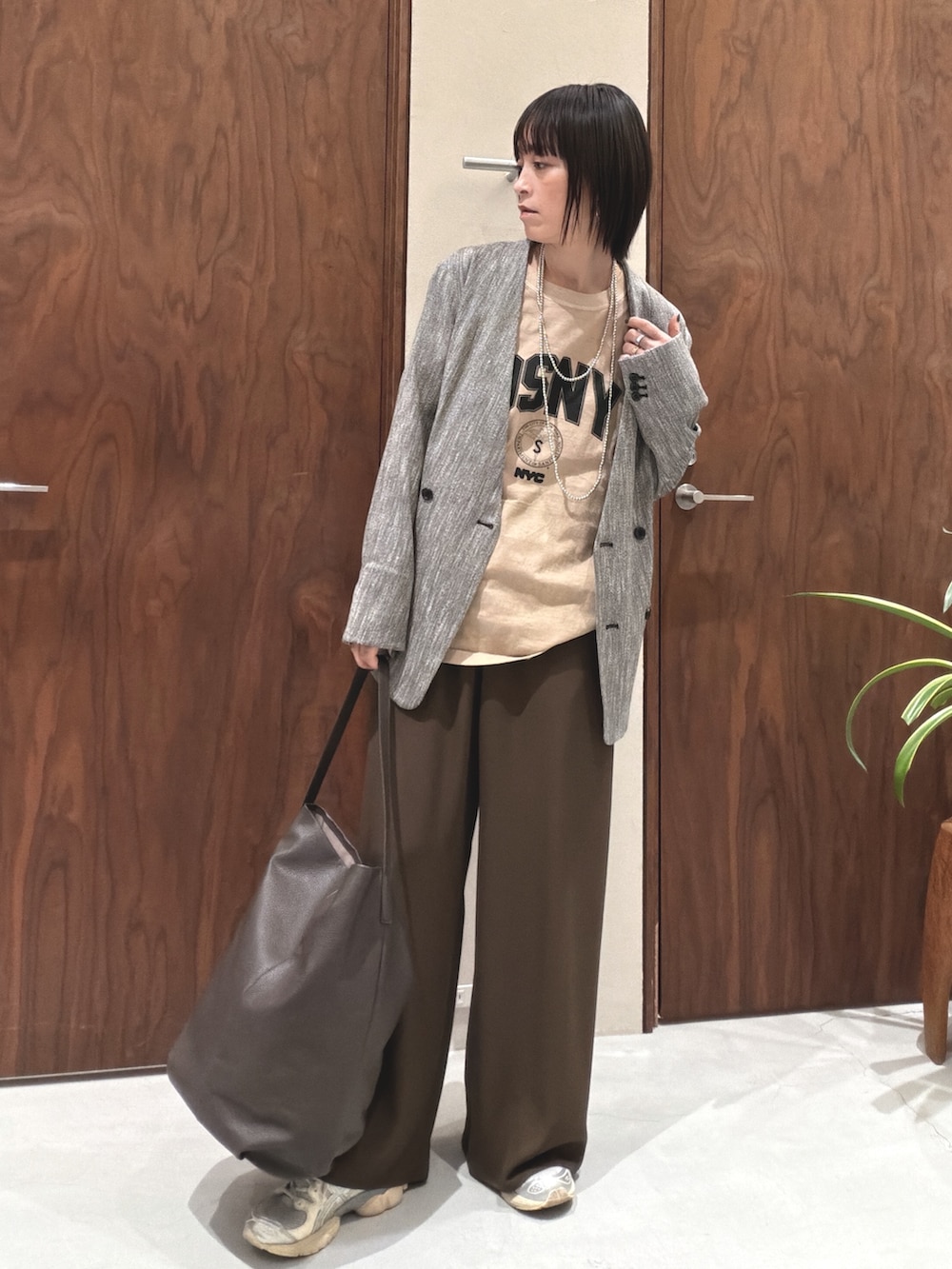 ブラック系のその他アウター、ベージュ系のTシャツ/カットソー、ブラウン系のショルダーバッグを着用したレディースの春コーディネートの3枚目の写真