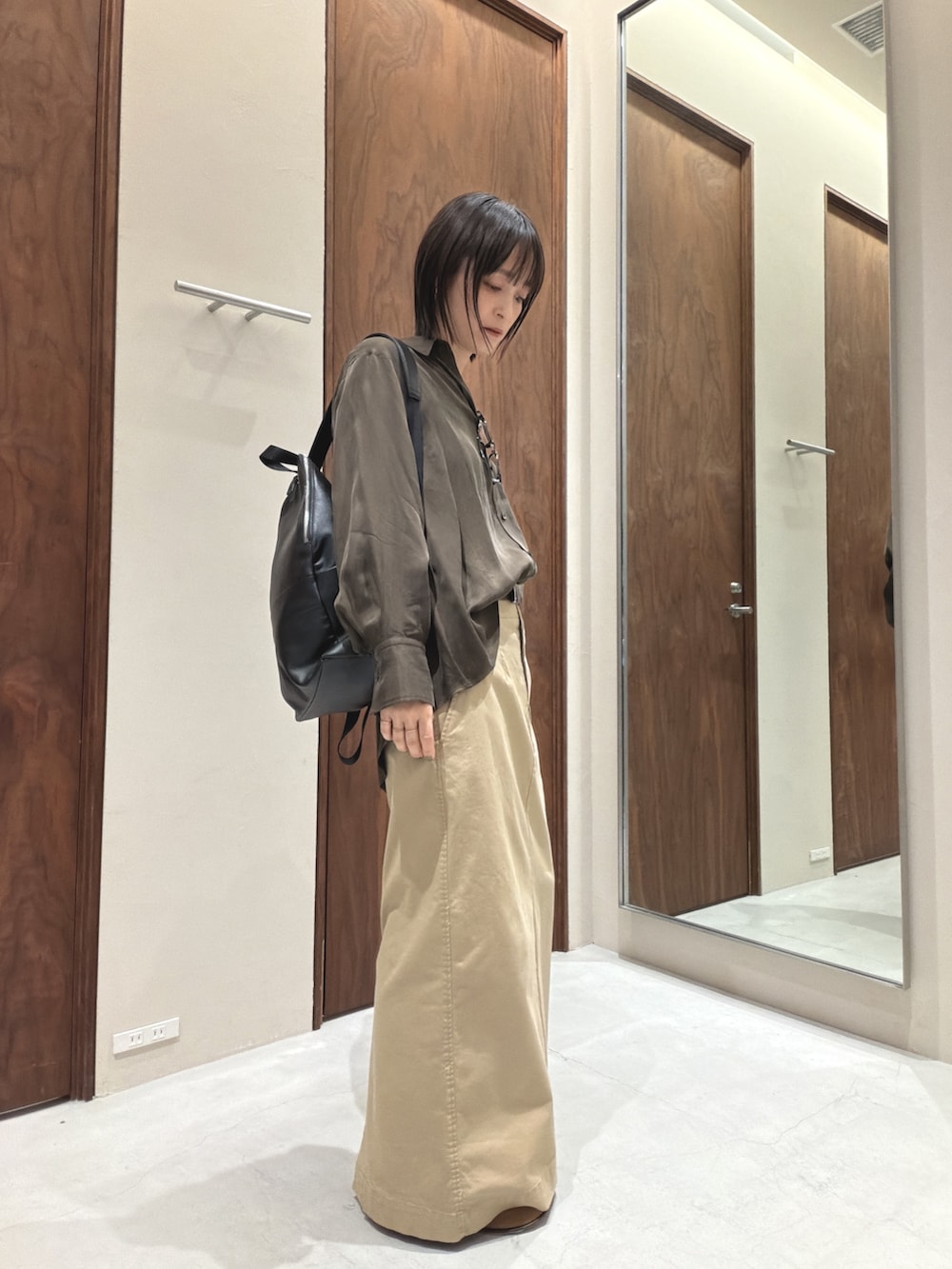 グリーン系のシャツ/ブラウス、ベージュ系のスカート、イエロー系のローファーを着用したレディースの春コーディネートの2枚目の写真