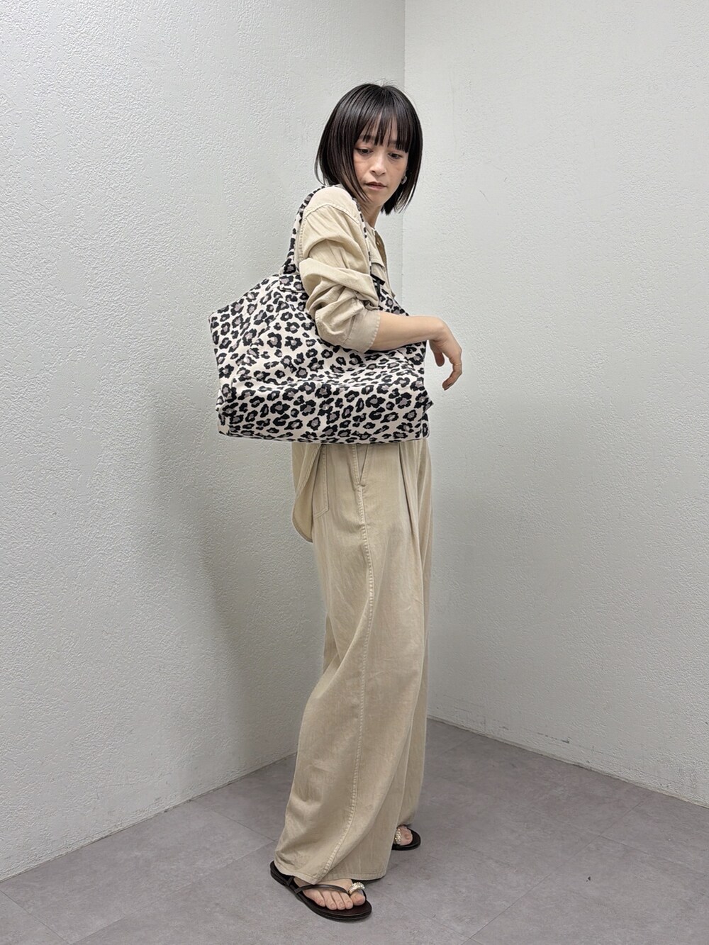 ベージュ系のシャツ/ブラウス、ベージュ系のその他パンツ、ブラック系のトートバッグを着用したレディースの春コーディネートの5枚目の写真