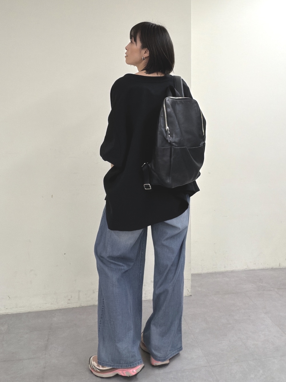 ブラック系のノーカラージャケット、ブラック系のニット/セーター、ブルー系のその他パンツを着用したレディースの春コーディネートの6枚目の写真