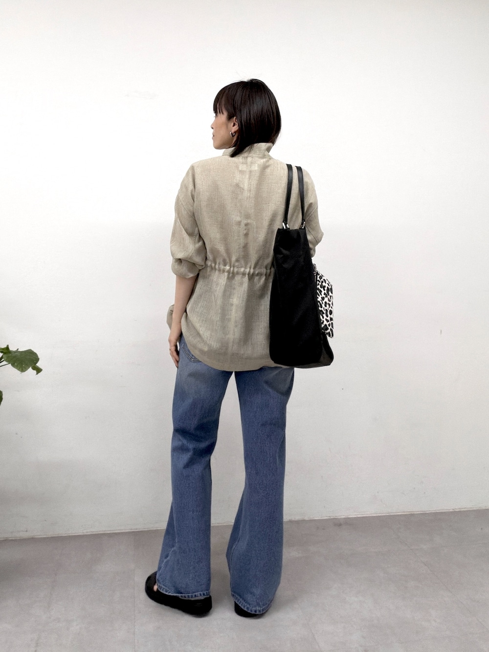 グリーン系のベスト、ブルー系のデニムパンツ、ブラック系のサンダルを着用したレディースの春コーディネートの3枚目の写真