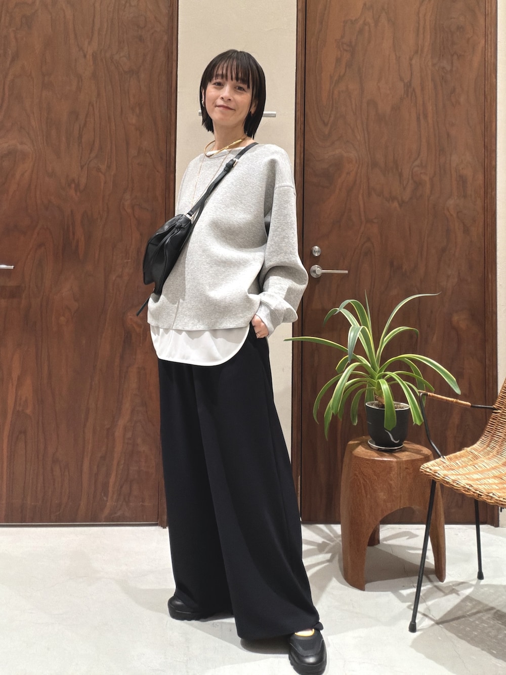 グレー系のTシャツ/カットソー、ブラック系のショルダーバッグ、ホワイト系のシャツ/ブラウスを着用したレディースの冬コーディネートの4枚目の写真