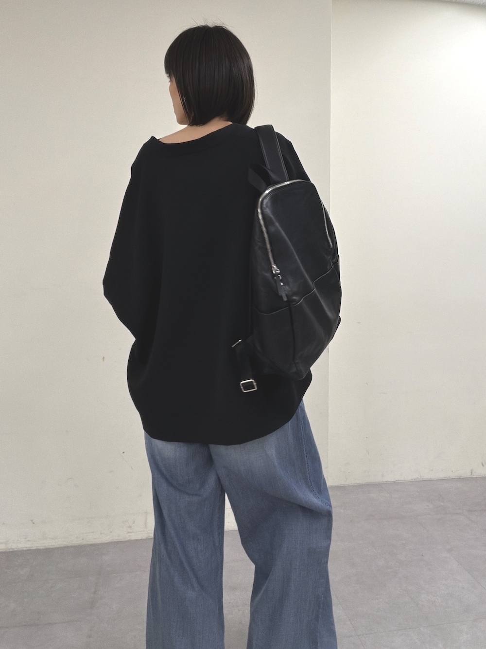 ブラック系のノーカラージャケット、ブラック系のニット/セーター、ブルー系のその他パンツを着用したレディースの春コーディネートの2枚目の写真