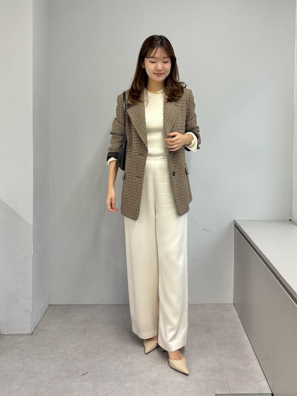 ブラウン系のテーラードジャケット、ホワイト系のニット/セーター、ホワイト系のその他パンツを着用したレディースの秋コーディネートの3枚目の写真