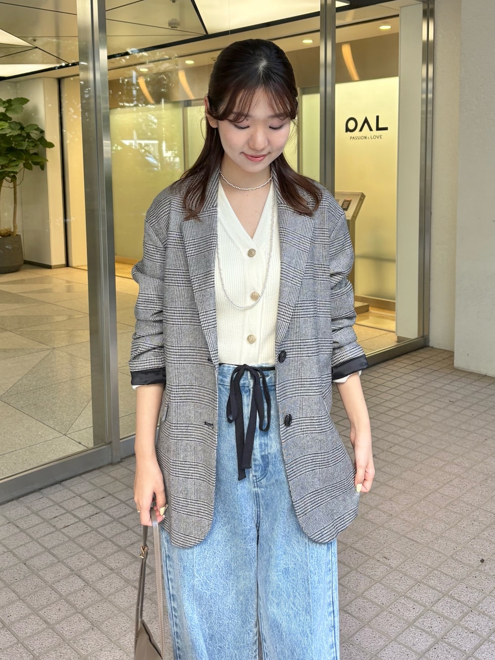 ブルー系のデニムパンツ、ブラウン系のパンプス、ブラウン系のショルダーバッグを着用したレディースの秋コーディネートの4枚目の写真