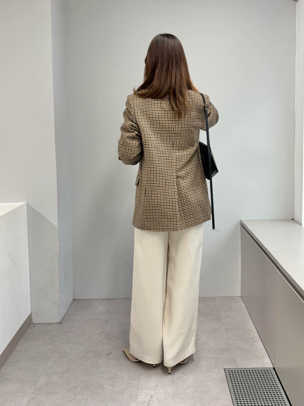 ブラウン系のテーラードジャケット、ホワイト系のニット/セーター、ホワイト系のその他パンツを着用したレディースの秋コーディネートの4枚目の写真