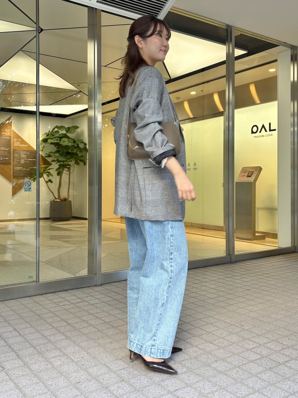 ブルー系のデニムパンツ、ブラウン系のパンプス、ブラウン系のショルダーバッグを着用したレディースの秋コーディネートの6枚目の写真