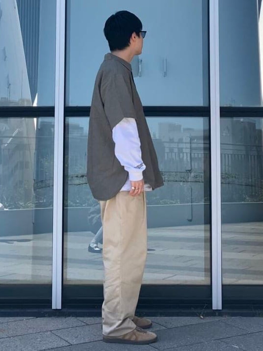 グリーン系のシャツ/ブラウス、ブラウン系のサングラスを着用したメンズの春コーディネートの3枚目の写真