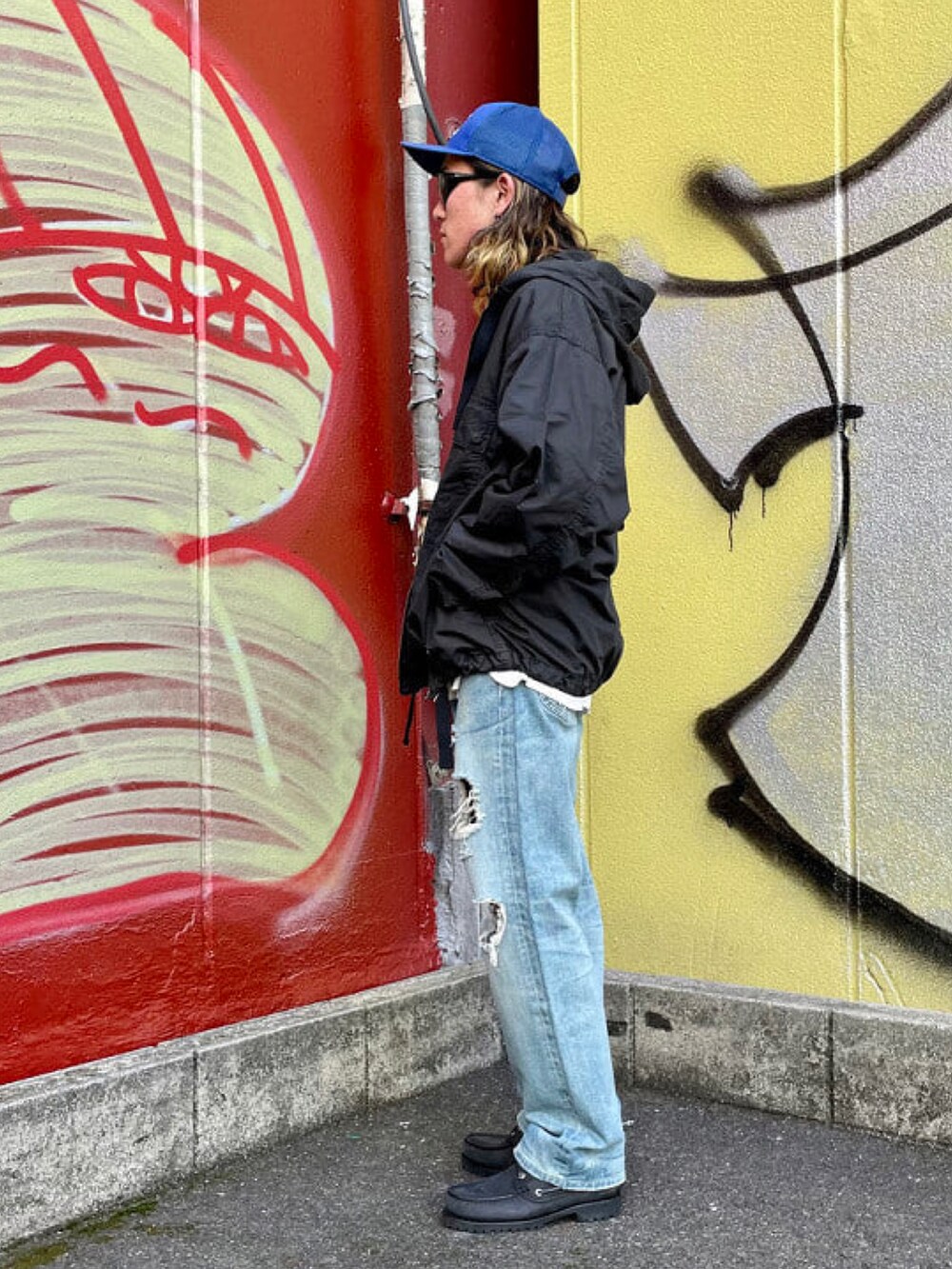 ブラック系のミリタリージャケット、ブルー系のデニムパンツ、グレー系のスウェットを着用したメンズの春コーディネートの2枚目の写真