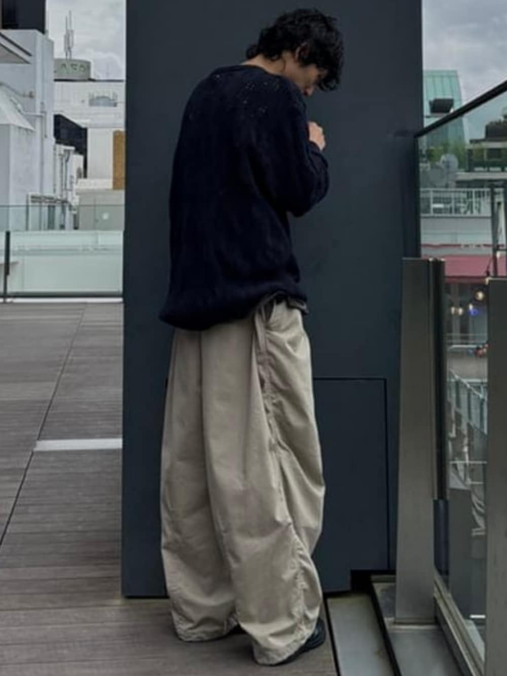 ブルー系のニット/セーター、ベージュ系のチノパンツを着用したメンズの夏コーディネートの3枚目の写真