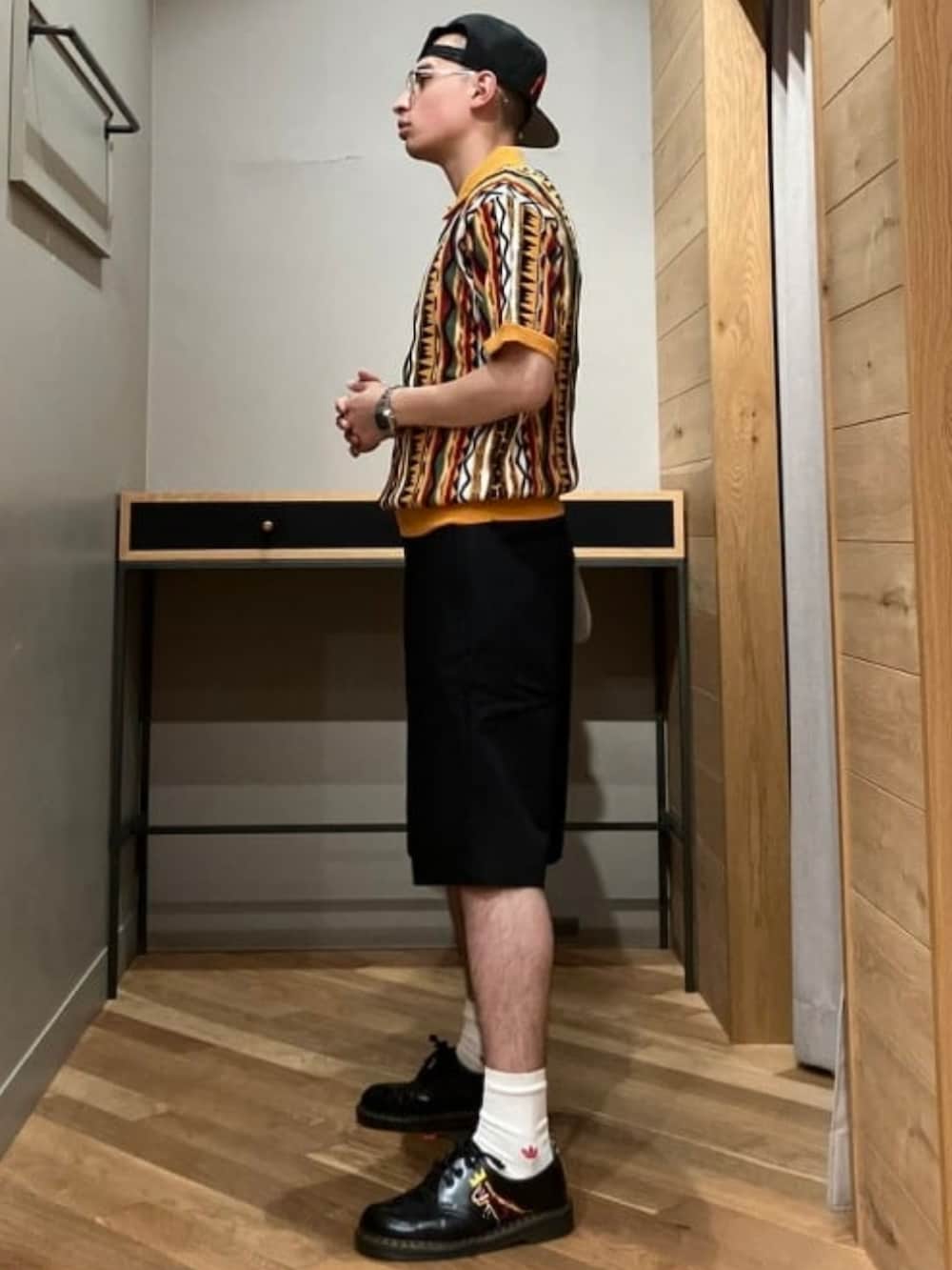 ベージュ系のその他パンツ、オレンジ系のポロシャツを着用したメンズの夏コーディネートの2枚目の写真