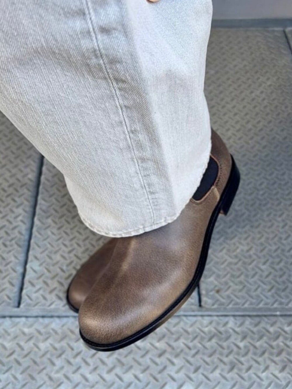 グレー系のデニムパンツ、ブラック系のドレスシューズを着用したメンズの夏コーディネートの3枚目の写真